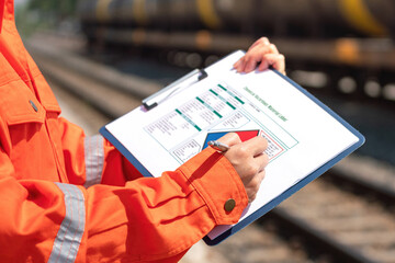 Wall Mural - action of an engineer is checking on the chemical hazard material form with background of crude oil 