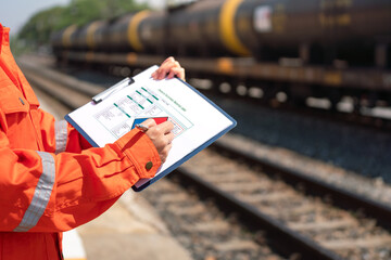 Wall Mural - action of an engineer is checking on the chemical hazard material form with background of crude oil 