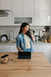 © Mihajlo Ckovric/Stocksy - Young Woman Drinking Coffee While Working on a Tablet in a Kitchen