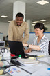 © Jovo Jovanovic/Stocksy - Smiling businesswoman showing colleague using laptop
