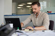© Jovo Jovanovic/Stocksy - Confident man with laptop at desk in office