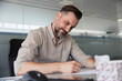© Jovo Jovanovic/Stocksy - Male manager writing document at desk