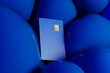 © Marcos Osorio/Stocksy - Bright blue credit card rests against a backdrop of vivid spheres