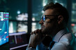 © seibertfilm - Thoughtful stock market analyst working in front of skyline window