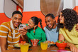 © BONNINSTUDIO/Stocksy - Young people enjoying meal and social media at restaurant