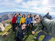 © Alvaro Lavin/Stocksy - Hikers taking selfie on top of mountain in Spain