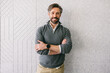 © VICTOR TORRES/Stocksy - Confident businessman standing against textured wall