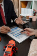 © kamiphotos - a lawyer is explaining the details of a car insurance policy to the car owner before she signs it, a lawyer explains to his client what will happen if she doesn't get car insurance