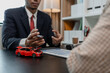© kamiphotos - a lawyer is explaining the details of a car insurance policy to the car owner before she signs it, a lawyer explains to his client what will happen if she doesn't get car insurance
