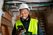 © Ezequiel Giménez/Stocksy - Smiling engineer using a smartphone