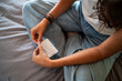 © Luis Herrera/Stocksy - Female Hands with Birth Control pills on Bed