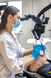 © puhimec - Young female dentist treating patient's teeth with dental microscope. Dentistry concept.