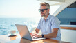 © Radorog. - businessman on a yacht with a laptop