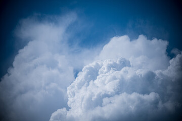 Wall Mural - fluffy white clouds float serenely in a bright azure sky, casting soft shadows below