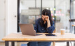 © David - Portrait of tired young business Asian woman work with documents tax laptop computer in office. Sad, unhappy, Worried, Depression, or employee life stress concept