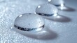 © Sang - Crystal clear water droplets rest on textured white, a visually appealing contrast showing hydrophobic properties, suitable for backgrounds.