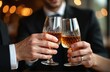 © miss irine - Closeup hands toasting whiskey glasses indoors at friendly party. Cheerful people celebrate holiday event, drink strong alcohol in restaurant. Luxury lifestyle business meeting with brandy or bourbon.
