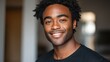 © Johannes - Smiling cheerful young adult african american ethnicity man looking at camera standing at home office background. Happy confident black guy posing for headshot face front close up portrait.