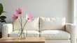 © Wonder Gallery - Serene living room arrangement featuring a minimalist off-white sofa and a delicate bouquet of pink flowers in a clear glass vase on a light wood coffee table