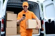 © Athena  - A smiling delivery driver in orange uniform uses a smartphone while holding a package in front of a van loaded with boxes
