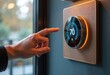 © starush - A person adjusting a smart thermostat to set the temperature at 70 degrees