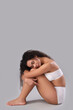 © Pixel-Shot - Beautiful young happy African-American woman with stretch marks on her body sitting against grey background