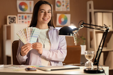 Wall Mural - female designer with paint color palettes at office in evening