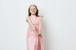 © SHOTPRIME STUDIO - A smiling girl in a pink dress with delicate sleeves, showcasing joy and innocence against a light background, perfect for children s fashion and celebrations