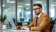 © Shams - Focused Professional: A distinguished professional is immersed in his work, meticulously typing on a laptop with a focused gaze, set against a modern office backdrop
