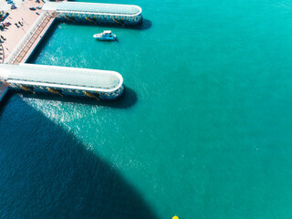 Poster - Aerial panorama of Hong Kong city port. Turquoise water surrounds docks and a boat, captured from a high angle viewpoint.