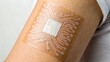© Stick Stack Stock - healthcare technology biotech biosensors, Smart skin patch with embedded technology on a person's arm.