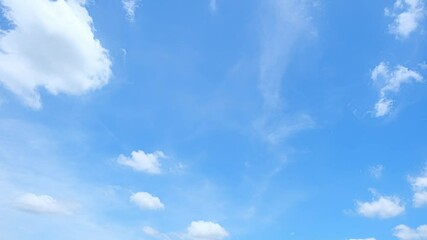 Wall Mural - A time-lapse view of a bright and clear sky, where the soft clouds drift slowly across the expansive blue canvas, capturing the beauty of the day's gentle transition.
