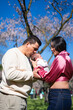 © Arianne - Loving parents kissing newborn baby in blooming park