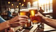 © Cliff - Hands of two friends clinking glasses of beer in a cafe, close-up