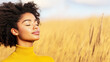© Vasili - African American woman in yellow sweater with closed eyes in golden wheat field. Her peaceful expression perfectly captures mindfulness, serenity and natural wellness concepts with text space.