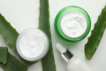Wall Mural - cosmetic products and aloe leaves on white textured background, flat lay