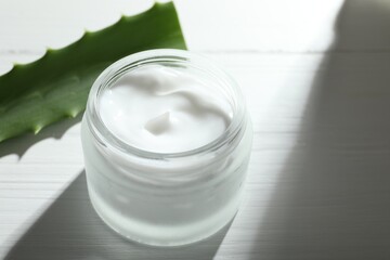 Wall Mural - cream and aloe leaves on white wooden background, closeup