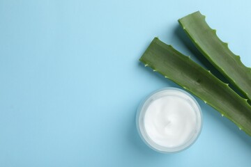Wall Mural - cream and aloe leaves on light blue background, flat lay. space for text