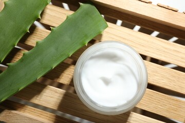 Wall Mural - cream and aloe leaves on wooden background, flat lay