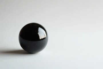 Poster - Smooth black obsidian sphere on simple light background with elegant reflections and shadows