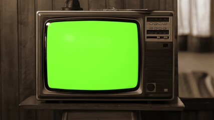 Wall Mural - vintage tv with green screen turning on and off by remote control, sepia tone - 100% real and not ai