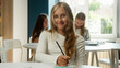 © Yuliia - Cute schoolgirl kid girl student Caucasian teen child gen z pupil learner at classroom writing task exam learn lesson exercise smiling teenager looking at camera education knowledge studying in school