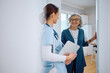 © Drazen - Happy elderly woman greeting visiting nurse at her doorway.