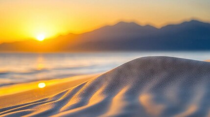 Wall Mural - a close-up shot of a sand dune with the sun setting behind distant mountains, and a tranquil body of
