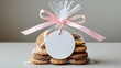 © ArtificialHorizons - Small gift featuring cookies in a plastic bag secured with a bow using a pink ribbon and a circular white gift tag attached.