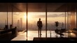 © Birul - Silhouette of a Person in Modern Office Overlooking Cityscape at Sunset