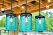 © vejaa - Glowing recycled glass lamps made from used jars, hanging in wooden terrace. Upcycling, sustainability, zero waste, repurposing, handmade decorations, reusing concept