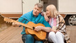 © Prostock-studio - Romantic family times. Mature man singing to his charming wife near their trailer outdoors. Panorama