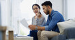© BuyoutReese10/peopleimages.com - Couple, documents or discussion with finance on sofa for mortage expenses, bills or invoices at home. Man, woman or paperwork with missed payments for financial report, debt or credit review at house