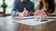 © ngamaz - Couple signs house papers near model home. Real estate purchase concept